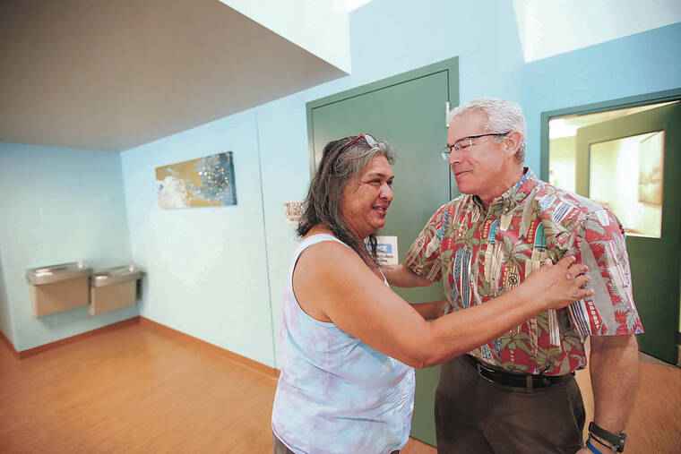Sharmane Botelho, left, embraced state Health Director Dr. Kenneth Fink on Tuesday at the Iwilei Resource Center.