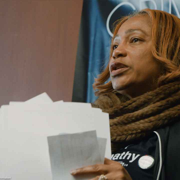 Pamela Winn holding papers in a still from the short film, WINN.